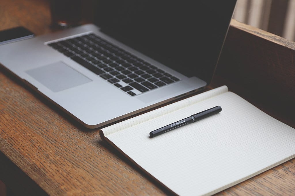 laptop notebook pen on wooden desktop